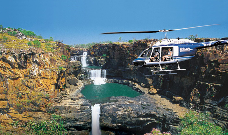 Helicopter flies over Mitchell Falls in the Kimberley