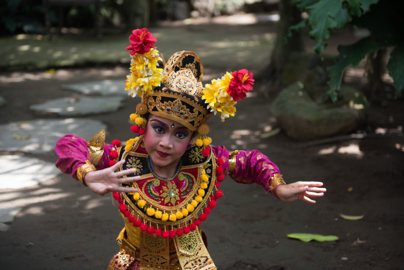 Balinese temple dancer poses in garden