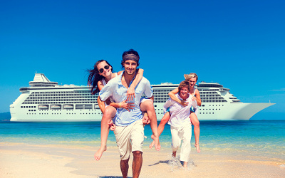 Couples piggy back on beach in front of cruise ship